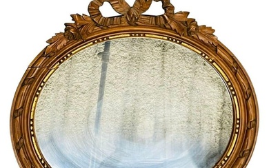 Louis XVI style gilt wood wall or console mirrorA sleek French oval gilt wood wall mirror having a
