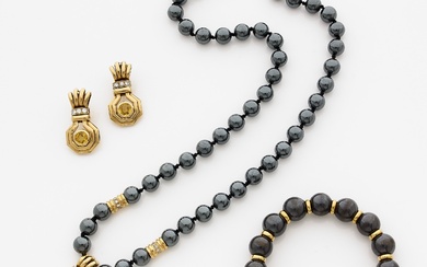 PARURE En or jaune, comprenant un collier ponctué de perles d'hématite retenant un motif d'or...