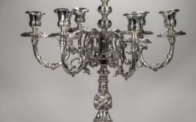 Pair of seven-arm candelabra in silver resting on a round base decorated with cherubs' heads in bas-relief, it rests on three scrolled legs overhung with figures in a round bust holding an eagle on their forearm, the shaft was made of caryatid