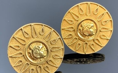 Paire de clips d'oreilles en or jaune à motif de soleil rayonnant et d'un profil de Minerve au centre.
