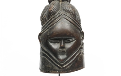 Sierra Leone, Mende, bundu helmet mask, showing a young girl's face, hairdo in tresses.