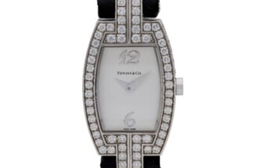 Tiffany & Co. A lady's 18ct white gold and diamond set quartz wristwatch with presentation box, Numbered 040940464, c.2008 silvered dial with applied white gold 12 and 6, and gold hands, quartz movement, brushed and polished tonneau shaped case...