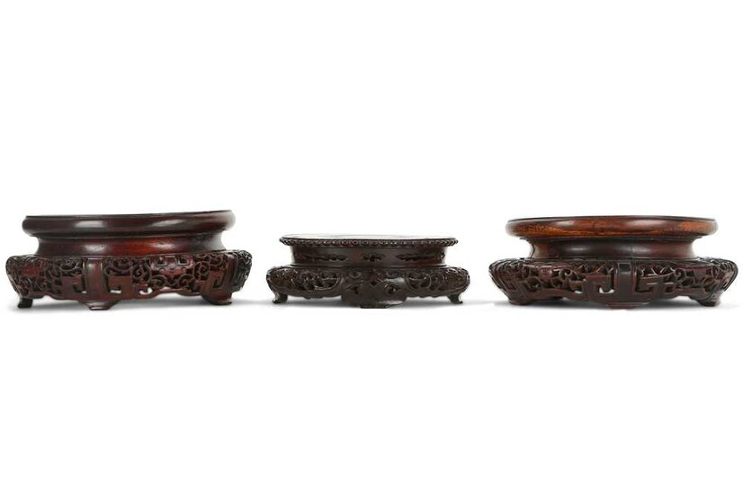 THREE CHINESE CIRCULAR WOOD STANDS. 19th / 20th Century....