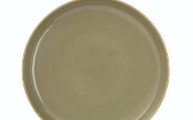 AN UNUSUAL CELADON-GLAZED SHALLOW DISH, YONGZHENG SIX-CHARACTER MARK IN UNDERGLAZE BLUE WITHIN A DOUBLE CIRCLE AND OF THE PERIOD (1723-1735)