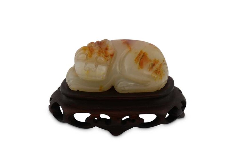 A CHINESE PALE CELADON JADE CARVING OF A LION.