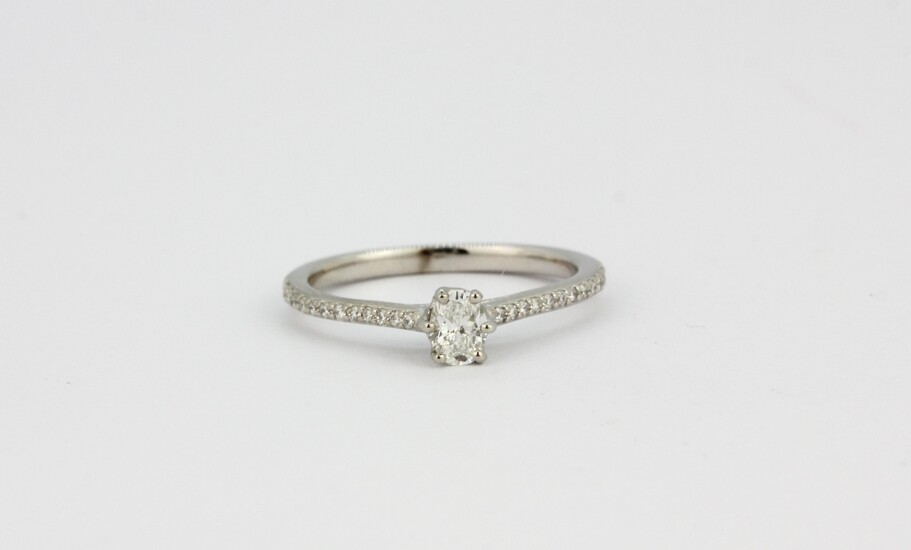 A Jenny Packham 18ct white gold oval cut diamond set solitaire ring with diamond set shoulders, approx. 0.33ct, (M.5).