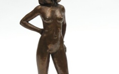 A PATINATED BRONZE FIGURE OF A STANDING FEMALE NUDE, RAISED ON A HARDWOOD BASE, 36 CM HIGH