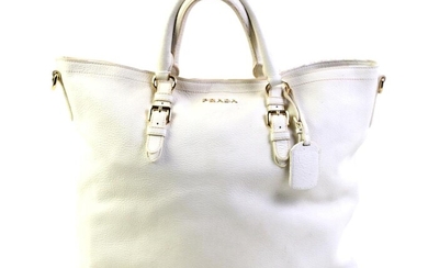 A PRADA CREAM VITELLO LEATHER TOTE BAG; with adjustable straps, luggage tag and gold tone hardware, missing shoulder strap, wear to...