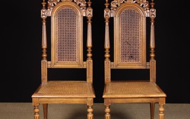 A Pair of 19th Century Carved Walnut Chairs with caned dome-topped backs and seats. The pierced cres