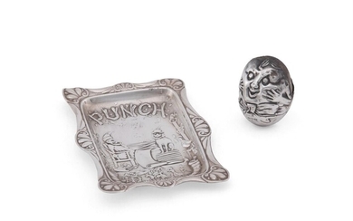 A SILVER NOVELTY PIN CUSHION AND A PUNCH MAGAZINE PIN TRAY, THE CUSHION NAMED HUMPTY DUMPTY