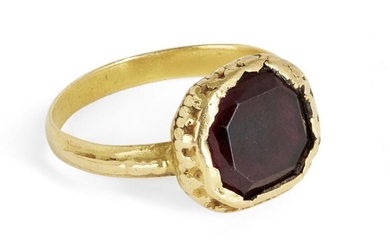 A garnet ring, centring on a mixed-cut octagonal garnet, inset to a textured mount, ring size K, unmarked