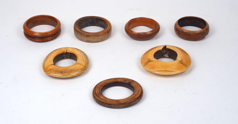 A group of mixed African ivory bangles, 19th century, of varying patinas an sizes, of round and lipped carved form, 7cm to 13.5cm diameter (8)