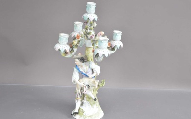 A late 19th-early 20th Century Sitzendorf German porcelain candelabra modelled with shepherd shearing a sheep