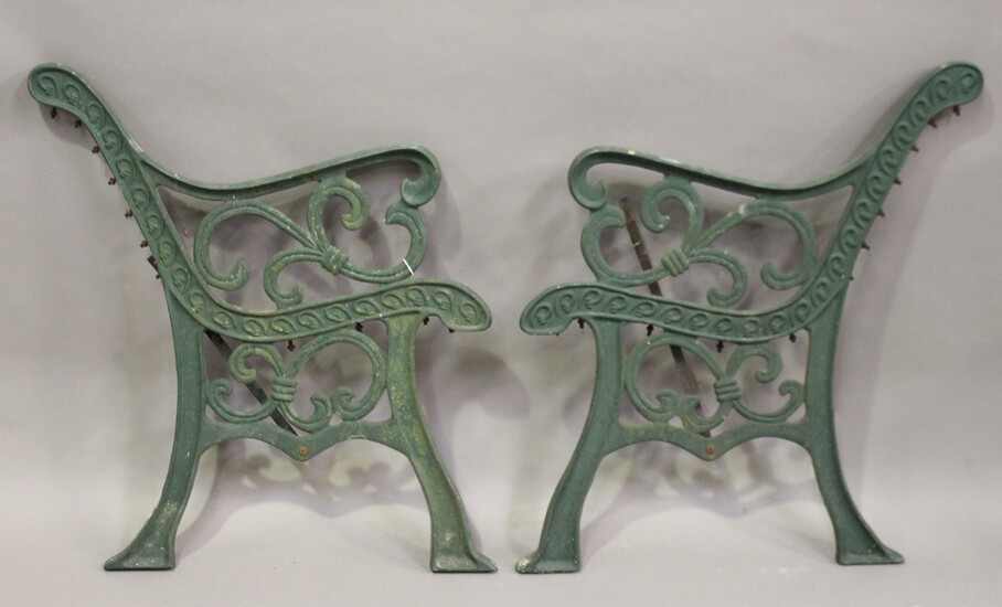 A pair of early 20th century green painted cast iron garden bench ends of scrolling form, height 78c