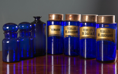A set of four blue glass cylindrical pharmacy jars