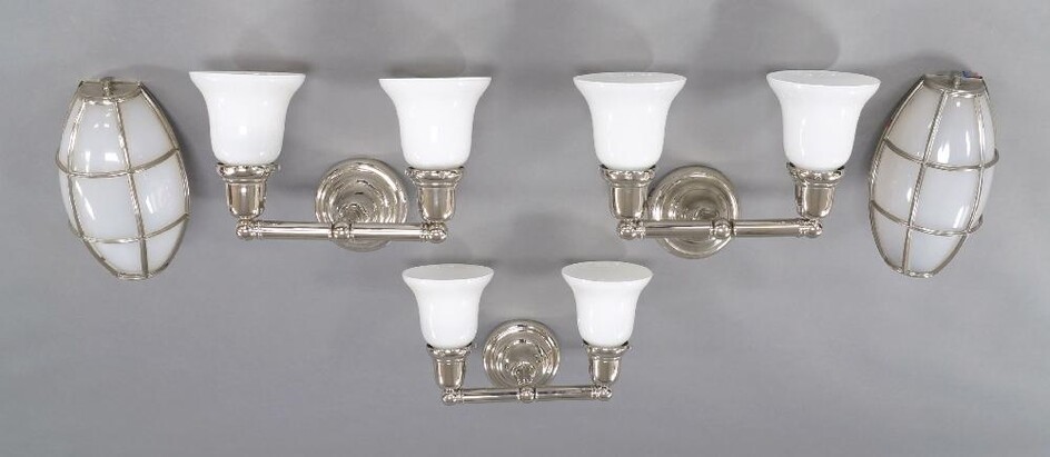 A set of three contemporary chromed twin branch metal wall lights, with white glass shades and circular wall mounts, each 27cm high, 35cm wide, 23cm deep; together with a pair of contemporary wall lights, each 30cm high (5) It is the buyer's...