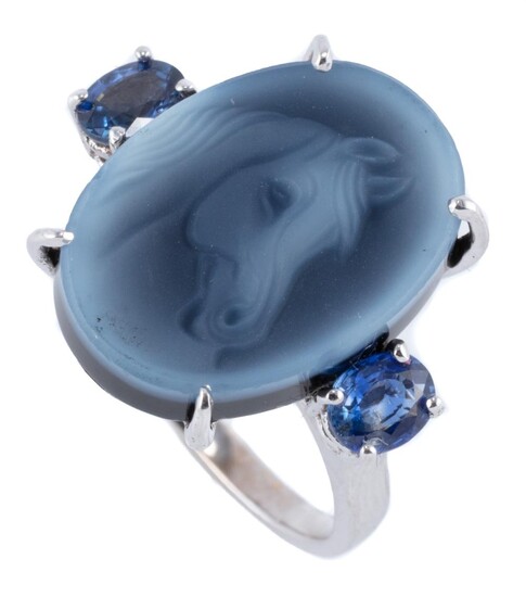 AN 18CT WHITE GOLD CAMEO AND SAPPHIRE RING; claw set with an 18 x 13mm cameo depicting a horses head between shoulders each set with...