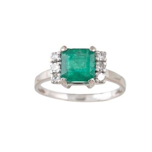 AN EMERALD AND DIAMOND CLUSTER RING, the trap cut emerald fl...