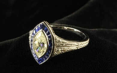 An 18 Carat White Gold Diamond & Sapphire Dress Ring. The marquise cut diamond measuring approx 9 mm