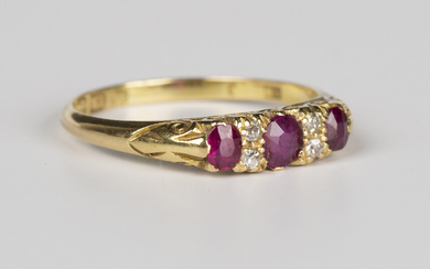 An 18ct gold, ruby and diamond ring, mounted with three cushion cut rubies alternating with two pair