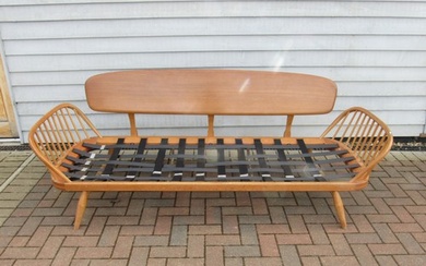 An Ercol light elm sofa "Day Bed" with plank back. No seat p...
