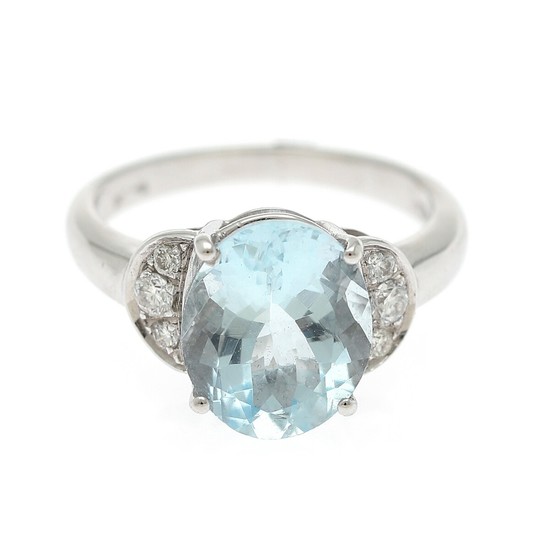 An aquamarine and diamond ring set with an oval-cut aquamarine flanked by six brilliant-cut diamonds, mounted in 18k white gold. Size 51.5.