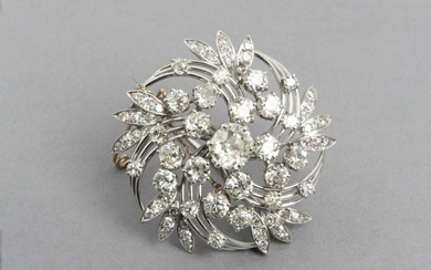Broche fleur en or gris 18K (750/1000) centrée d'un diamant taille ancienne d'environ 1 carat,...