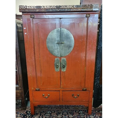 Chinese red finished blind panelled two door cupboard, havin...