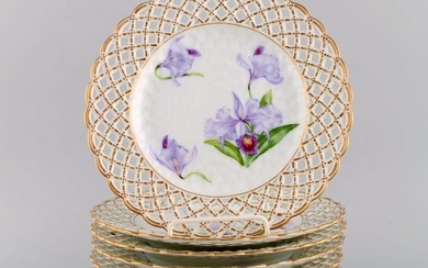Eight antique Royal Copenhagen plates in openwork porcelain with hand-painted purple lotus flowers.