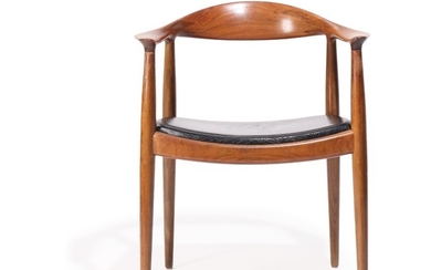 Hans J. Wegner: “The chair”. Nutwood armchair, upholstered in seat with black leather. Made by cabinetmaker Johannes Hansen.