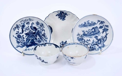 Lowestoft tea bowls and saucers, including a tea bowl painted in blue with trailing flowers, another printed with flowering plants within a fenced enclosure, a fluted saucer printed with panels of...