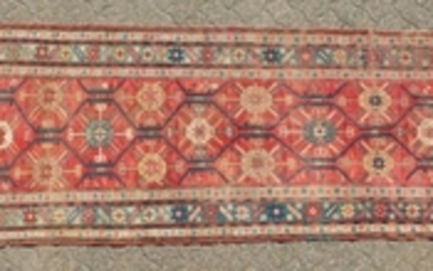 A CAUCASIAN RUNNER with typical motifs in red and blue.