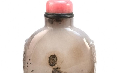 CHINESE BLACK AND WHITE AGATE SNUFF BOTTLE In flattened ovoid form, with mask and mock ring handles. Height 2.75". Pink stone stopper.