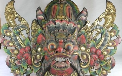 A large Balinese mask carved as a mythical beast.