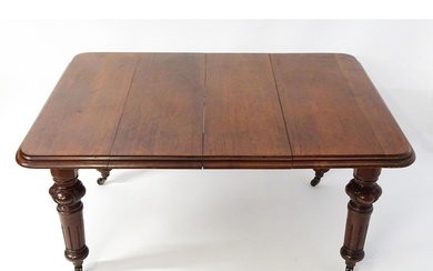 A 19thC mahogany dining table with a moulded top edge raised...