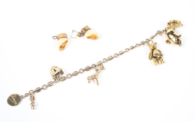 A 9ct gold charm bracelet set with six 9ct gold charms, and two gold mounted teeth earrings.