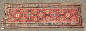 A CAUCASIAN RUNNER with typical motifs in red and blue.
