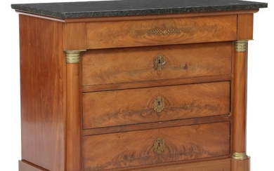 A Charles X mahogany chest of drawers with black Belgian granite top. Ca. 1830. H. 88 cm. W. 103 cm. D. 52 cm.