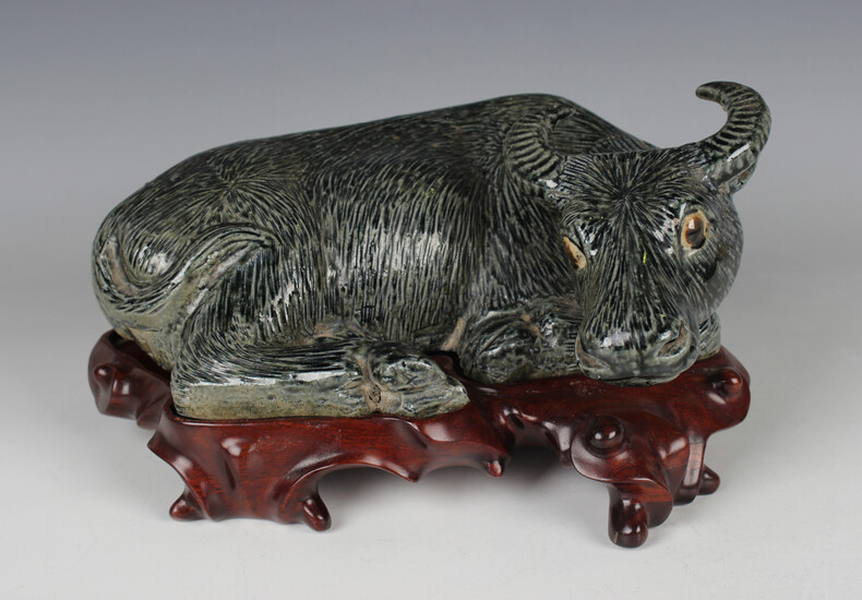 A Chinese pottery figure of a recumbent water buffalo, late Qing dynasty, modelled in a recumbent po