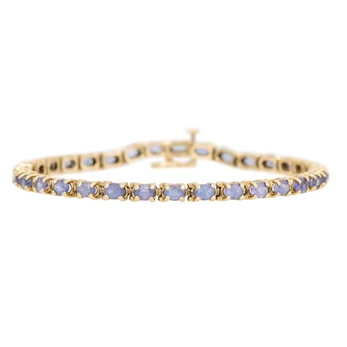 A TANZANITE LINE BRACELET, mounted in 14ct yellow gold