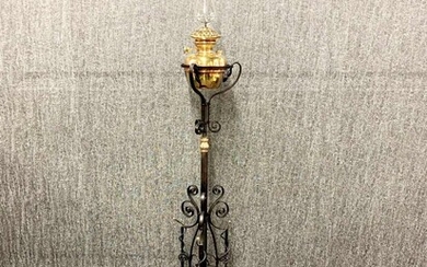 A Victorian telescopic wrought iron and brass oil lamp with a spare chimney, H. 151cm (with chimney).