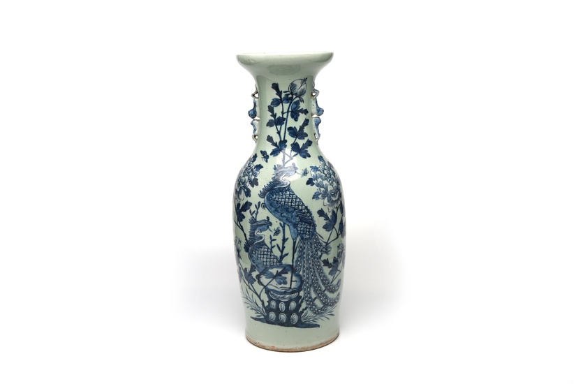 A blue and white porcelain vase painted with phoenix perching on rockery among peonies on a celadon ground