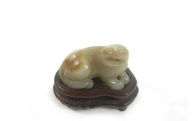 A carved jade lion-dog and wood stand