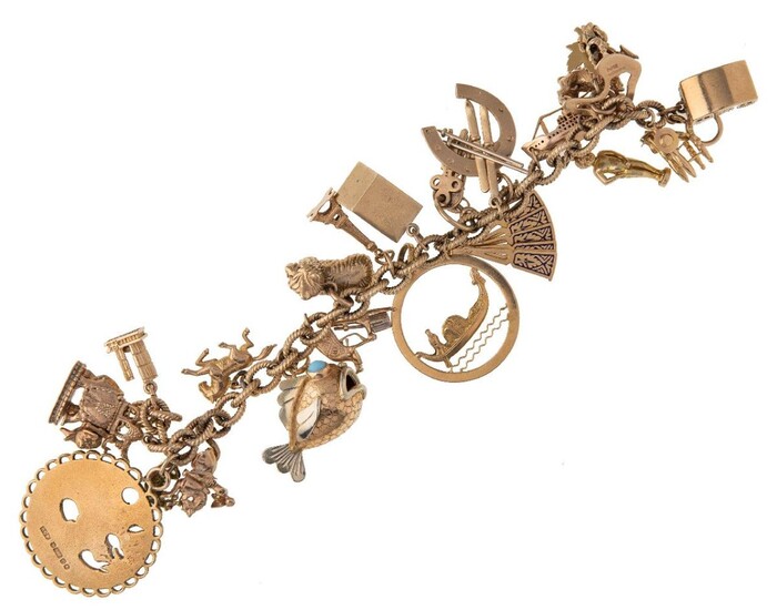 A charm bracelet, of twisted curb link design supporting twenty one various charms, including a liner, caravan and Yorkshire terrier, most with British hallmarks for 9-carat gold, c.1960, length 19cm