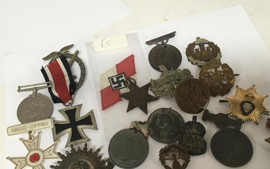 A collection of military badges and medals commemorative med...