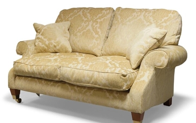 A cream upholstered three piece suite, comprising two seater settee and two matching armchairs, each upholstered in a stylised foliage pattern cream upholstery; the settee 79cm high, 160cm wide, 100cm deep; the chairs 80cm wide (3)