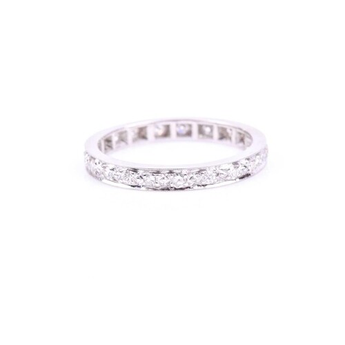 A diamond eternity band ring, the white metal shank inset wi...