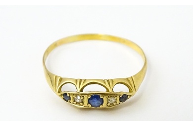 A gold ring set with diamonds and sapphires. Ring size appro...