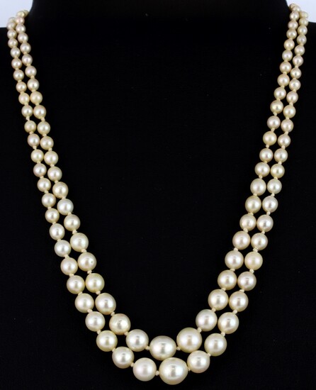 A graduated pearl set double strand necklace with a yellow metal (tested minimum 9ct gold) clasp set with old cut diamonds and sapphires, es