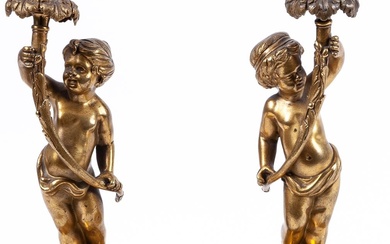 A pair of French ormolu candlesticks with putti on...